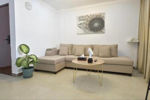 a living room with a couch and a table at Noble Rose Apartment in Kuwait