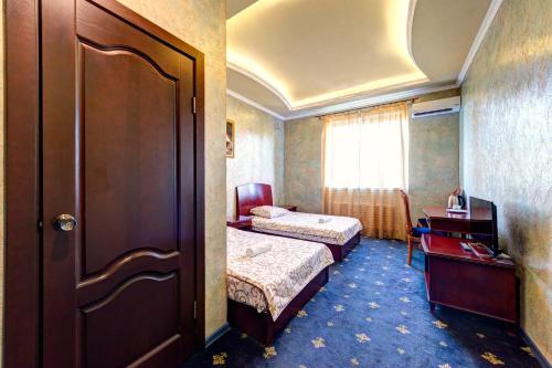 キーウにあるHotel Kiev Lomakinのベッド2台とドアが備わるホテルルームです。