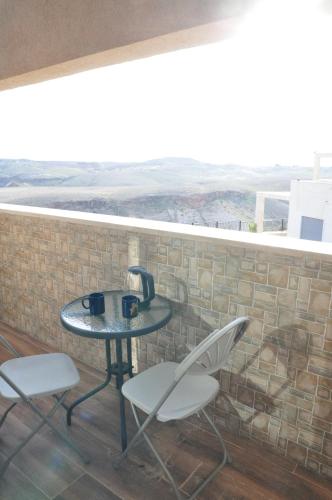 a table and chairs on a balcony with a view at Vastu Dead Sea apartment in Arad