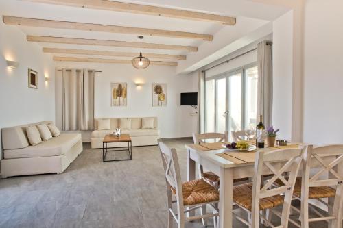 a living room and dining room with a table and chairs at Alsalos villas in Amoopi