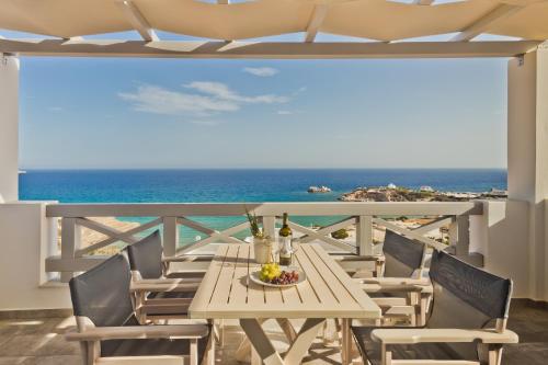 a table and chairs on a balcony with the ocean at Alsalos villas in Amoopi