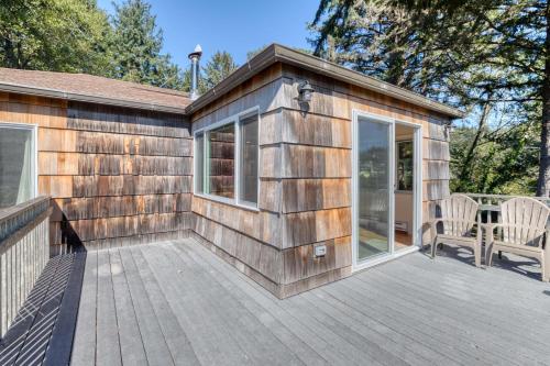 a wooden cabin with a deck with a table and chairs at Bamboo House - Meredith Lodging in Nehalem