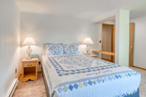 a bedroom with a blue and white bed and two lamps at Bamboo House - Meredith Lodging in Nehalem