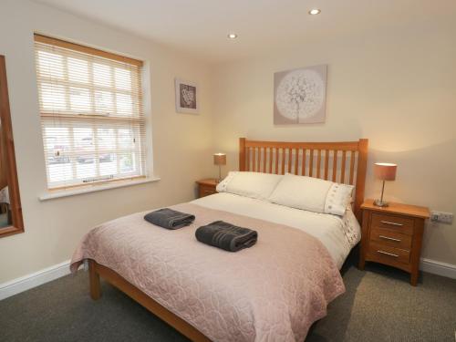 Un dormitorio con una cama grande y una ventana en Whistle Stop Apartment en Porthmadog