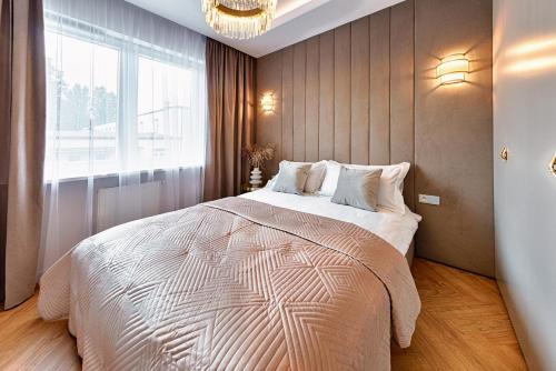 sypialnia z dużym łóżkiem i dużym oknem w obiekcie Wyjątkowy Taupe Apartament w centrum Łodzi w Łodzi