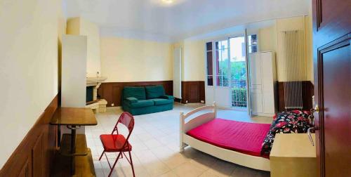 une chambre avec un lit et un canapé bleu dans l'établissement Comfortable Paris 5, à Vitry-sur-Seine