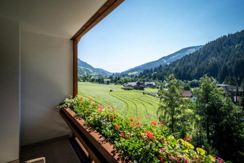 a balcony with a view of a field of flowers at Hotel OTP Birkenhof in Bad Kleinkirchheim