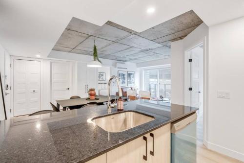 eine Küche mit einem Waschbecken und einem Esszimmer in der Unterkunft Initial / Cinéma +Parking / Centre-ville de Québec in Québec