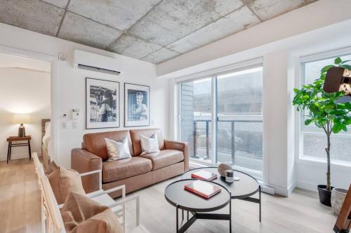 a living room with a couch and a table at Initial / Cinéma +Parking / Centre-ville de Québec in Quebec City