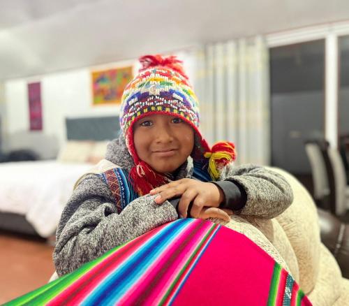 a young girl wearing a hat holding a kite at TITICACA JALTAWI LODGE in Puno
