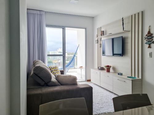a living room with a couch and a large window at Estada inesquecível 08 Bacutia/Guarapari Premium in Guarapari