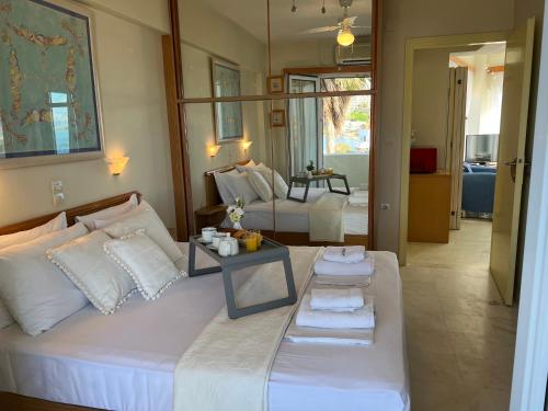 a bedroom with a white bed with a table on it at Sea Breeze in Kalamaki