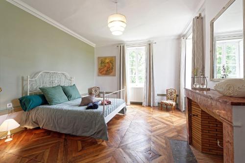 um quarto com uma cama com um urso de peluche sentado sobre ele em château de millery 