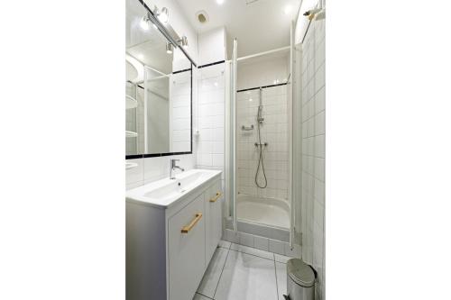 uma casa de banho branca com um lavatório e um chuveiro em château de millery 