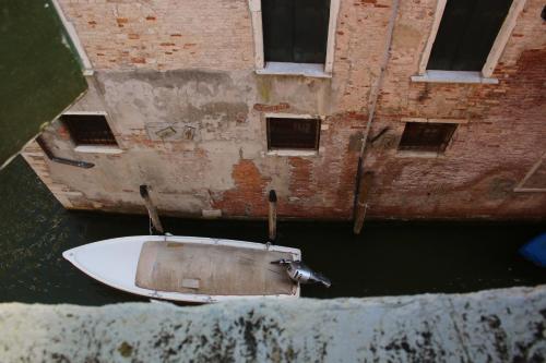 a boat sitting in the water next to a building at Penthouse Of Venice in Venice