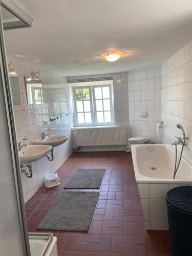 a large bathroom with two sinks and a tub and a tub at Gutshaus Wohlenhagen in Wohlenberg