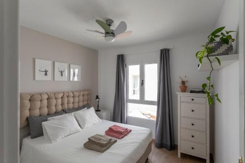 1 dormitorio con 1 cama con sábanas blancas y ventana en Casablanca House, en Corralejo