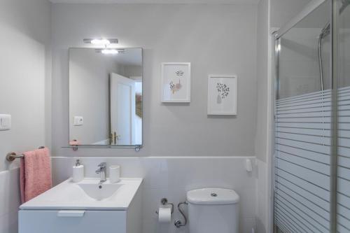 a bathroom with a toilet and a sink and a mirror at Casablanca House in Corralejo