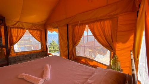 a bed in a tent with two windows at Ananta Prana in Mussoorie