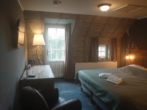 ein Schlafzimmer mit einem Bett, einem Stuhl und einem Fenster in der Unterkunft De Cyprian Bed & Breakfast in Baaiduinen