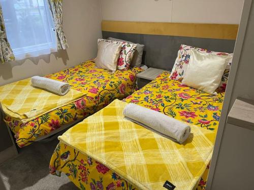 two beds sitting next to each other in a room at The Warrens - 2 bed caravan for 4 & private hot tub in Swarland