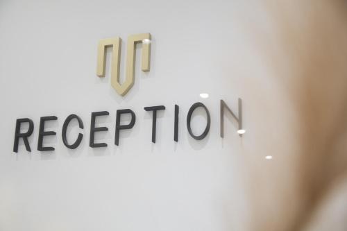 a sign with the words reception on a wall at Minimal Culture Boutique hotel in Kavala