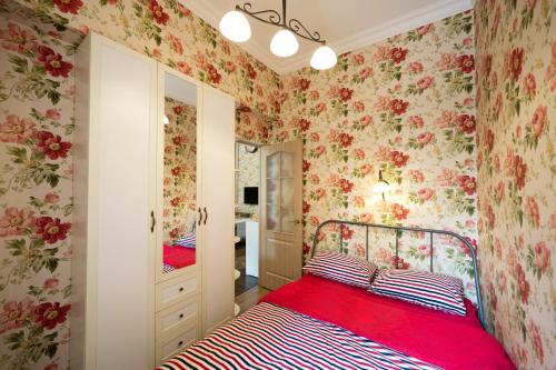 una camera da letto con un letto rosso con carta da parati floreale di Cozy Central apartment a Yerevan