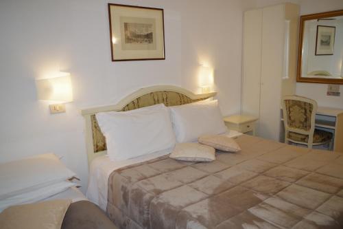 a bedroom with a bed with two pillows on it at Hotel Casa Petrarca in Venice