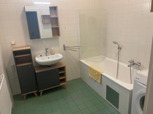 een badkamer met een wastafel, een bad en een wastafel bij Gesamte Unterkunft für 4 Personen Top 12 in Wenen