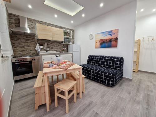 a kitchen and living room with a table and a couch at La casa di Teresa in Taranto