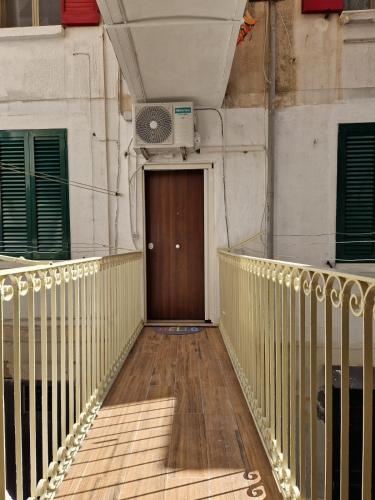 a wooden walkway with a brown door and green windows at La casa di Teresa in Taranto