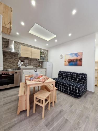 a kitchen and living room with a table and a couch at La casa di Teresa in Taranto