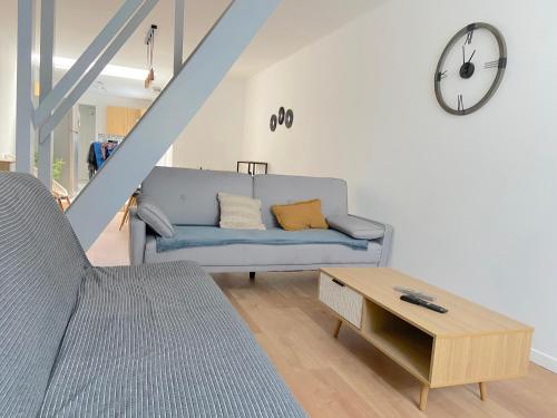 - un salon avec un canapé et un réveil sur le mur dans l'établissement Cozy house for 8 people near LILLE, à Tourcoing