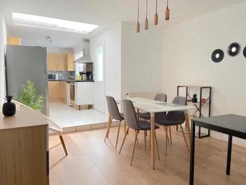 une cuisine et une salle à manger avec une table et des chaises dans l'établissement Cozy house for 8 people near LILLE, à Tourcoing