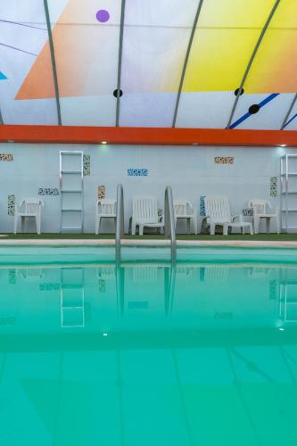 a swimming pool with chairs and a swimming pool at Hotel Yekkan in Huauchinango