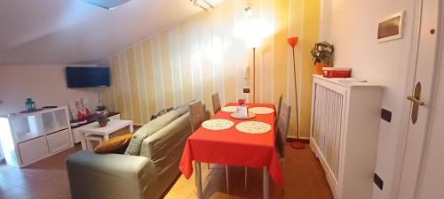 a living room with a table and a couch with a red table cloth at DINO IL MANSARDINO in Ome