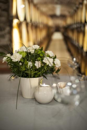 a white vase with white flowers on a table at Piwnica Rycerska Kęty in Kęty