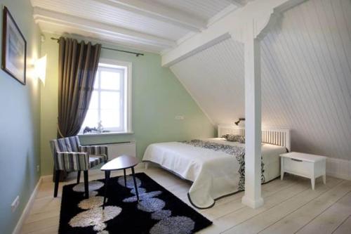 um quarto com uma cama, uma mesa e uma janela em Vila Pervalka em Pervalka