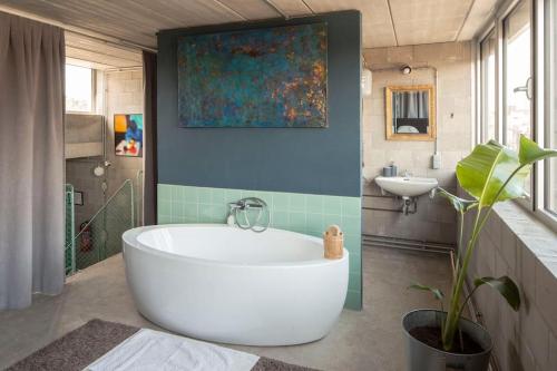 een badkamer met een groot bad en een wastafel bij Mari's: Multifunctional Shelter with big Garden in Gent