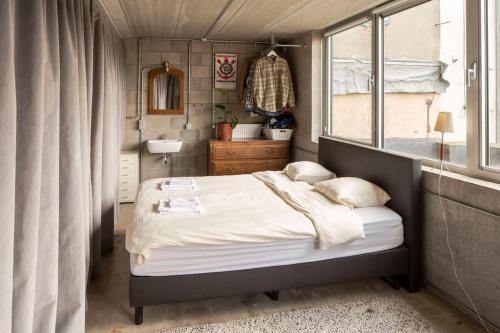 a small bedroom with a bed and a window at Mari's: Multifunctional Shelter with big Garden in Ghent