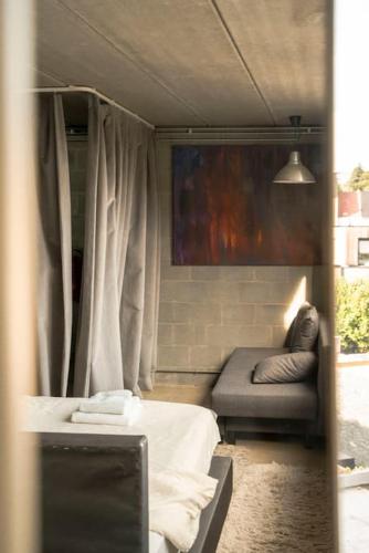 a room with a bed and a couch in it at Mari's: Multifunctional Shelter with big Garden in Ghent