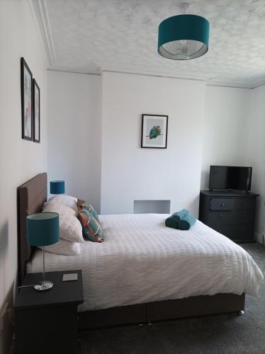 a bedroom with a large bed with a blue lamp at Victorian Renovation Room 4 in Liverpool