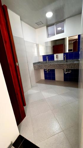a kitchen with blue and white walls and a tile floor at Hospedaje Lycaste in Tibasosa
