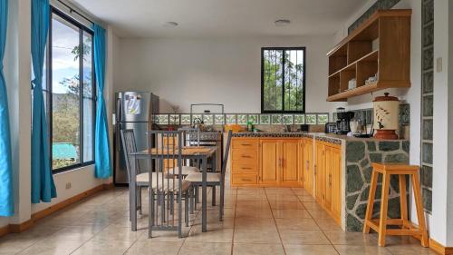 a kitchen with wooden cabinets and a table and chairs at Alpha House in Vilcabamba