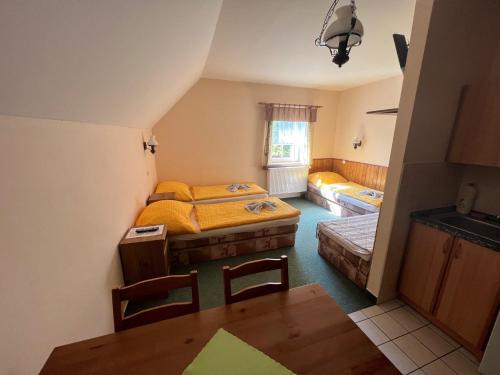 - une chambre avec 2 lits, une table et des chaises dans l'établissement Chalupa Na stráni, à Čenkovice
