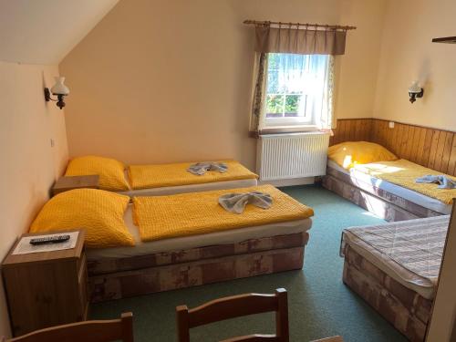 a bedroom with two beds and a window at Chalupa Na stráni in Čenkovice