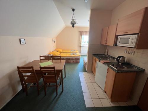 a small kitchen with a table and chairs and a bed at Chalupa Na stráni in Čenkovice