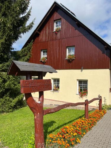 a wooden sign in front of a red barn at Chalupa Na stráni in Čenkovice