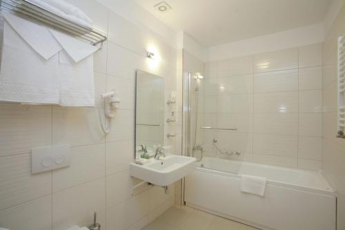 un bagno bianco con lavandino e vasca di Mari Vila Hotel a Bucarest