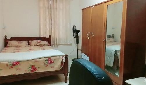 a bedroom with a bed and a dresser and a mirror at Adorable 2bedroom homestay in Beau Bassin